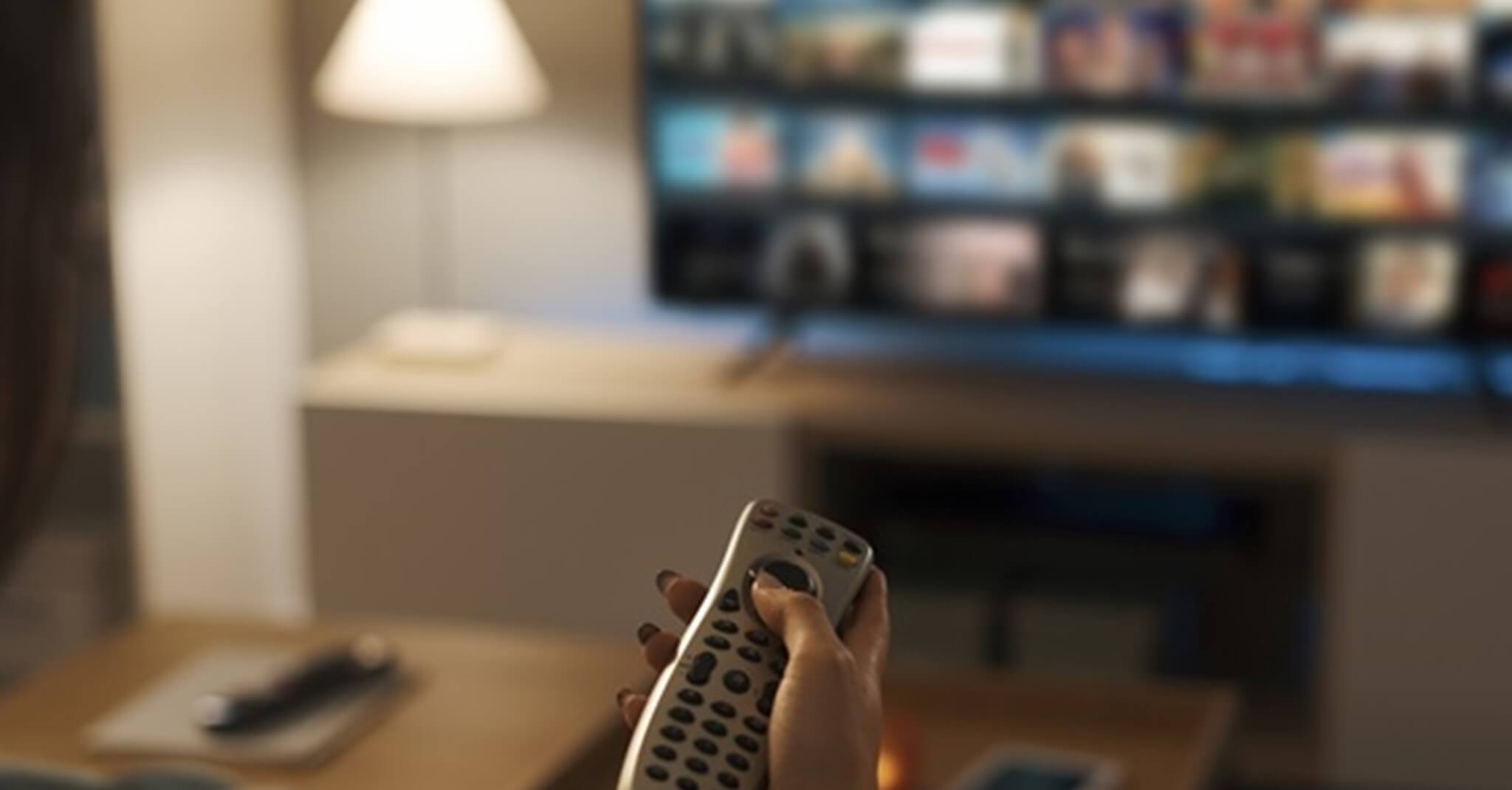 Young Woman Watching Video On Demand On Her Tv