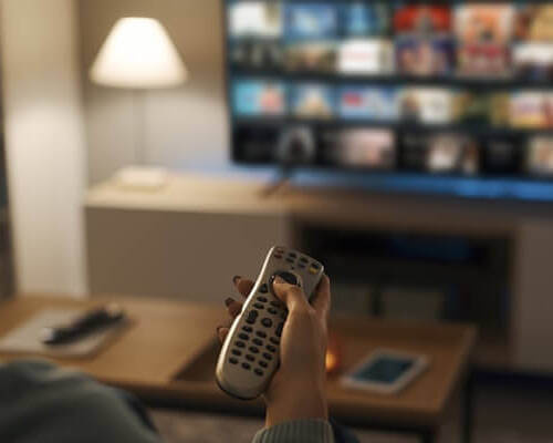 Young Woman Watching Video On Demand On Her Tv